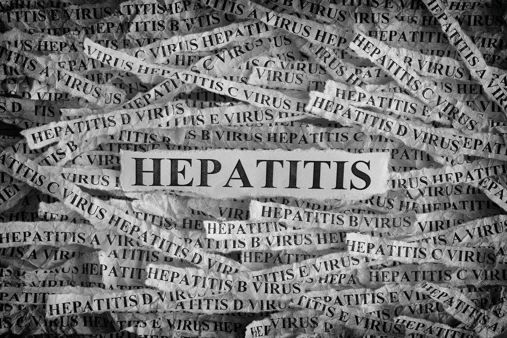 Torn pieces of paper with the words Hepatitis