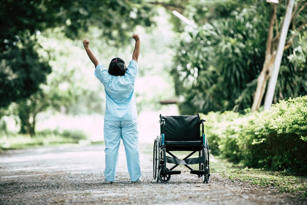 Physical therapy senior woman with wheelchair in the park