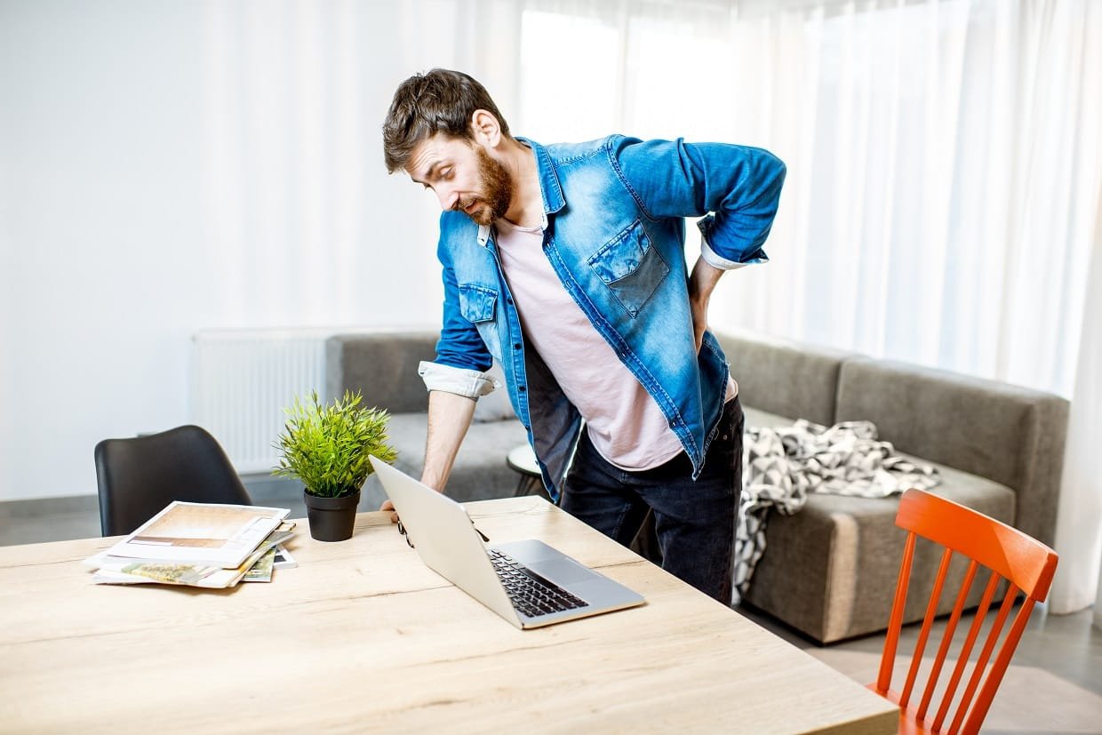 Man feeling back pain at home