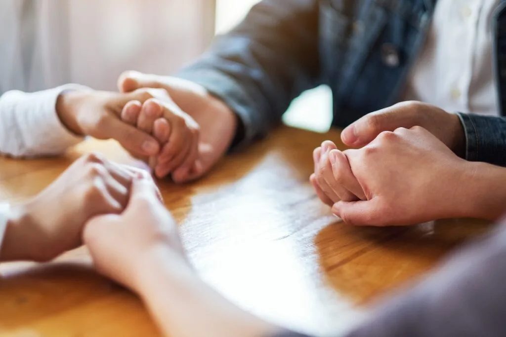 group-of-people-sitting-in-a-circle-holding-hands